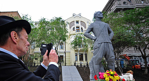 Rock Brynner tirando uma foto do monumento de seu pai.
