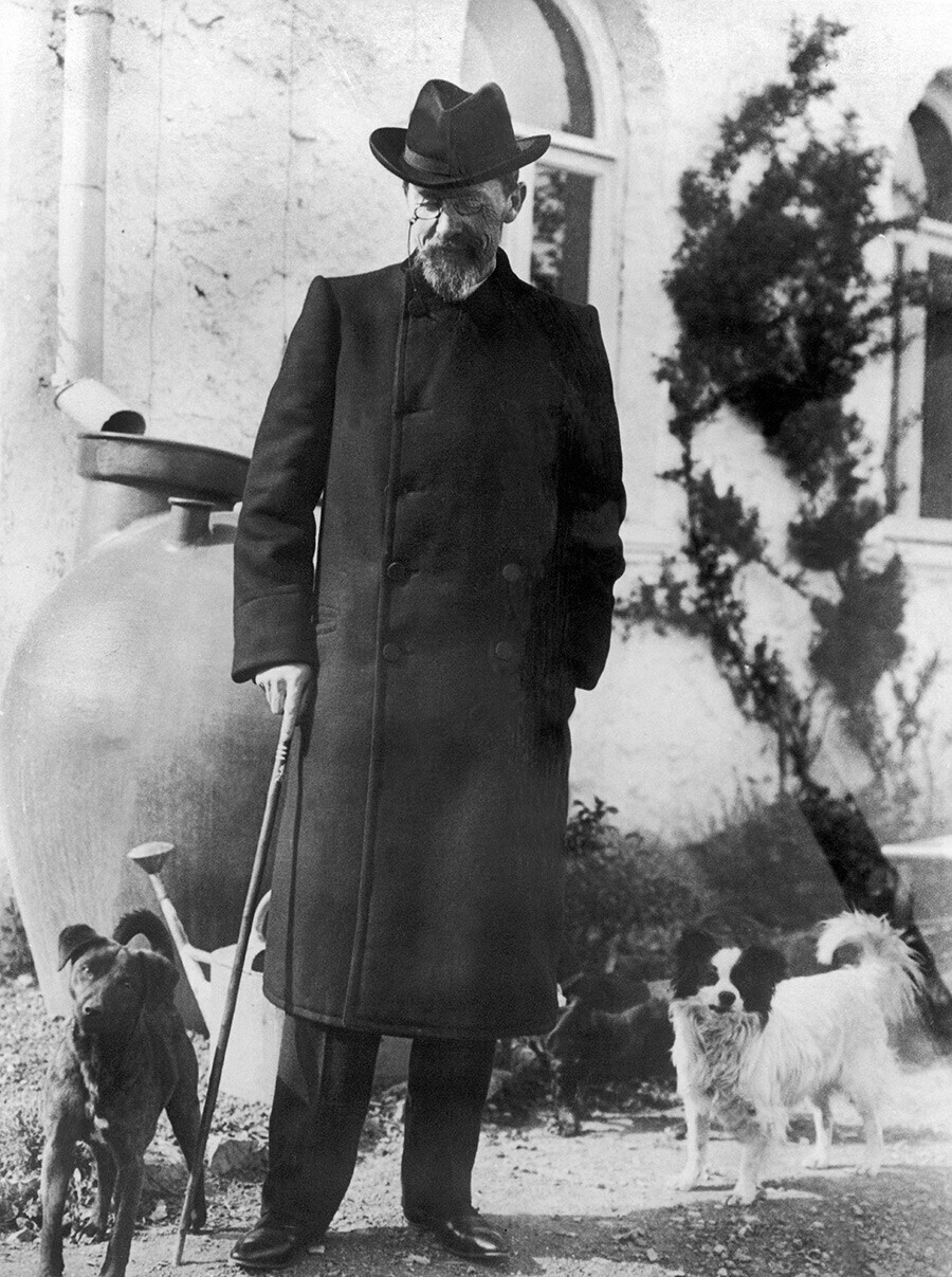 Tchékhov posando em Ialta ao lado de seus dois cães em 1901.
