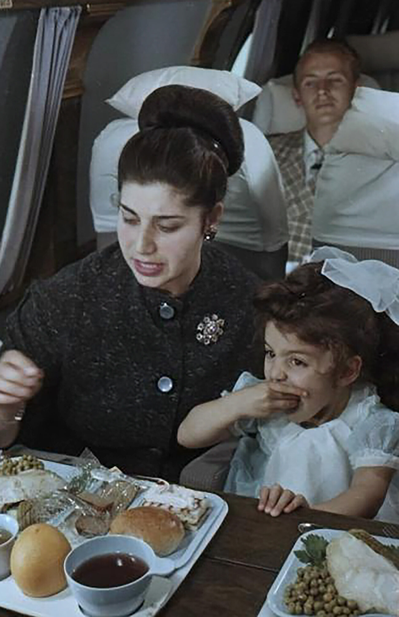 A woman and child on board an airplane, 1960s.