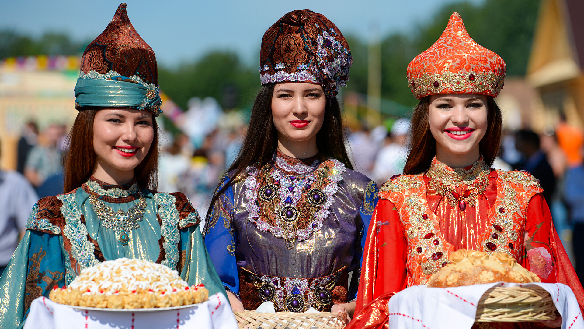 Девушки в национальных костюмах встречают гостей хлебом с солью и чак-чаком перед официальном открытием праздника Сабантуй в Казани. 