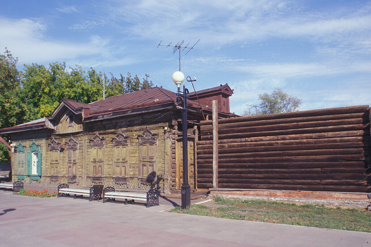 Maison en bois située au 50 de la rue Tara. À droite, mur en rondins d’un entrepôt. Photographie prise par William Brumfield le 15 septembre 1999