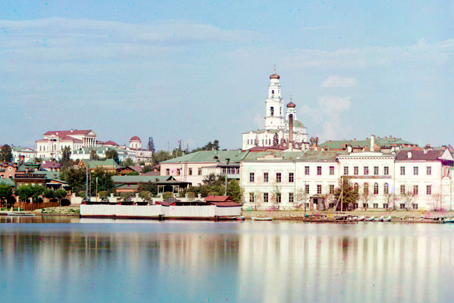 Ekaterinbourg. Vue depuis l’étang en direction de la colline de l’Ascension. De gauche à droite : palais Kharitonov, maison Ipatiev (visible en partie sous le portique de la façade principale du palais Kharitonov), clocher-tour et église de l’Ascension. Été 1909