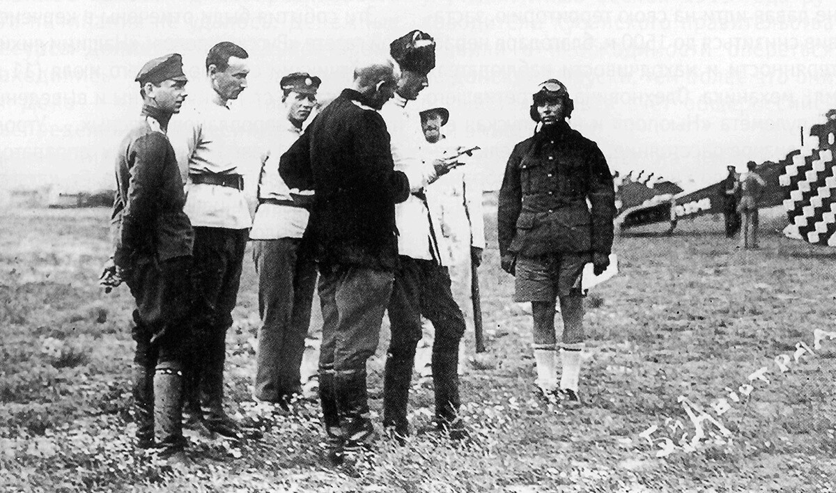 Comandante do Exército Russo, general Wrangel, conferindo o relatório do piloto do 5º destacamento de aviação. À sua frente vê-se um piloto em shorts tropicais britânicos.