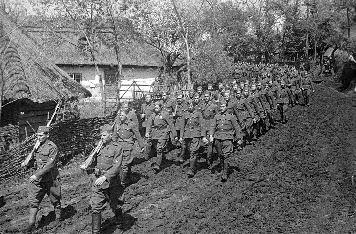 Czechoslovak soldiers marching along a Ukrainian village.