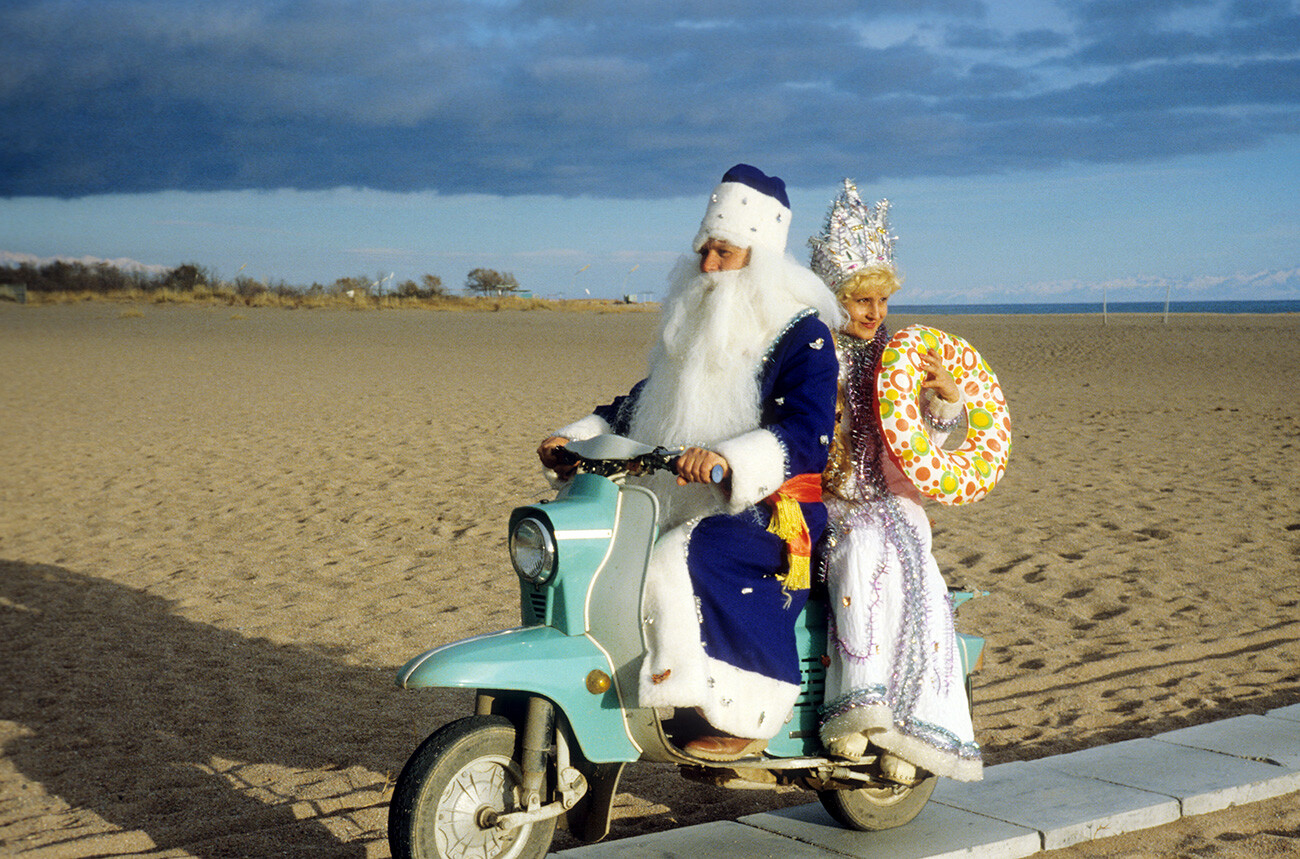 Le Père Gel et la Jeune fille des neiges sur un scooter sur la rive du lac Issyk-Koul, en Kirghizie soviétique, 1981

