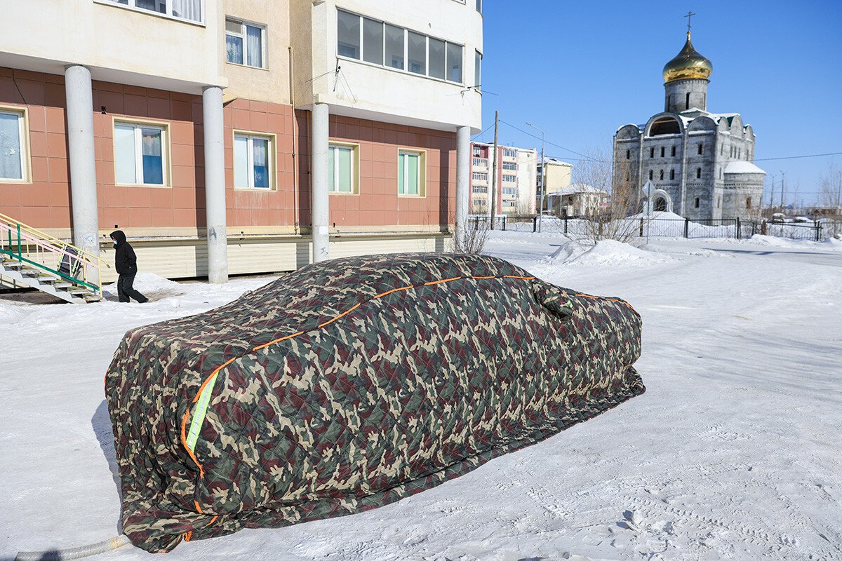 Carro envolto em uma capa de inverno enquanto termômetros marcam 38 graus Celsius negativos.