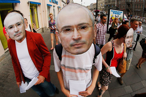 Russian opposition protesters wearing masks depicting jailed tycoon Mikhail Khodorkovsky march downtown St.Petersburg marking his 50th birthday, Russia, Wednesday, June 26, 2013. credit AP