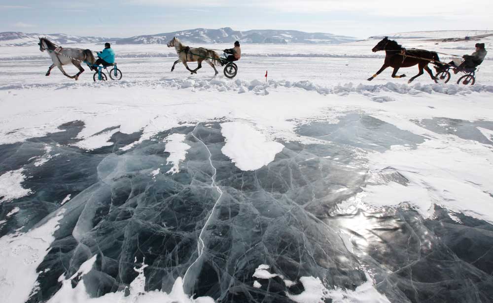 Para pengunggang kuda berlomba di Sungai Yenisei yang beku dalam pacuan kuda amatir Ice Derby, yang telah diselenggarakan tahunan setiap akhir musim dingin sejak 1969.