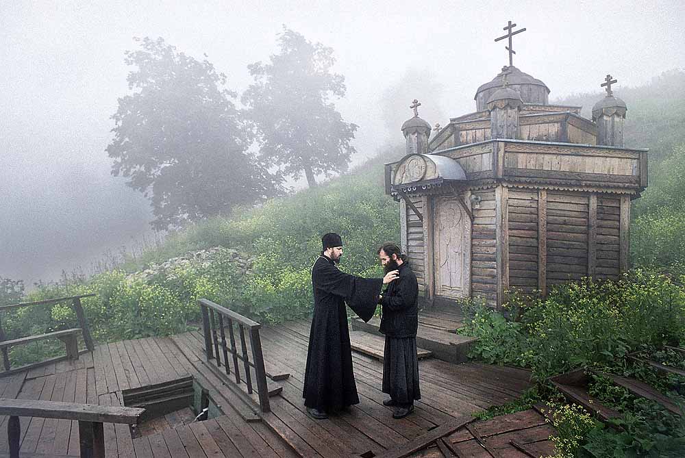 Monastère Nikolaïevsk Belogorsk, territoire de Perm. Situé dans les montagnes de l'Oural, où les schismatiques, les serfs, et les voleurs ont fui pour échapper à la répression et aux persécutions. Le monastère a été fondé en 1897 par les Vieux-croyants afin d'accomplir un travail missionnaire. Restauré en 1990. Sur la photo, l'hiéromoine Alipi parle à un habitant du monastère près de la source sacrée de Saint Nicolas le Thaumaturge.