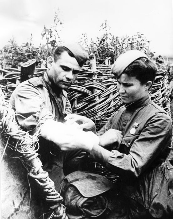 De acordo com estimativas mais recentes, enfermeiras e médicas soviéticas ajudaram a curar mais de 70% dos feridos durante a Segunda Guerra Mundial. Quinze médicas receberam o título de Herói da União Soviética por sua coragem especial. Na foto, enfermeira coloca curativo em um soldado ferido durante a batalha de Kursk, em 1943.