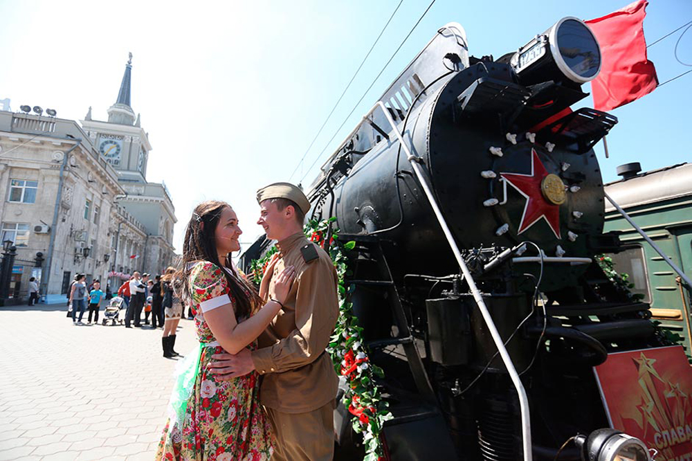 Young people wearing war-time clothes stand at the retro train &quot;Victory&quot; that has arrived at Volgograd railway terminal to mark the 70th anniversary of the Battle of Stalingrad.