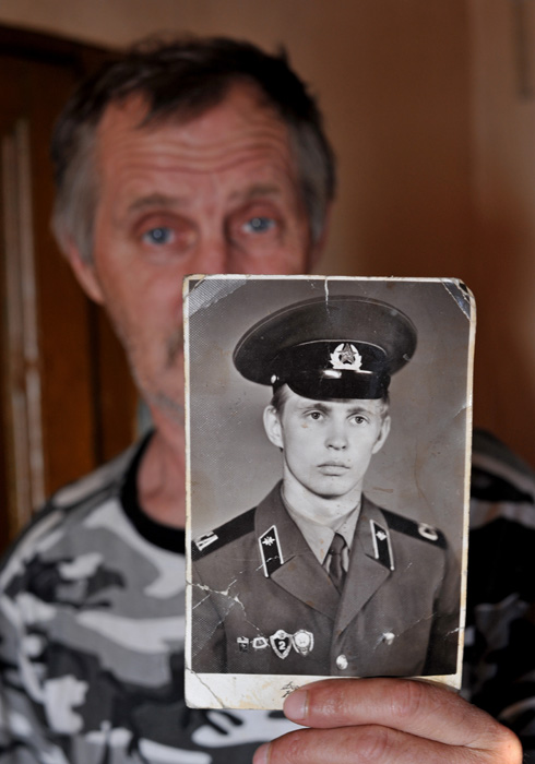 軍隊時代の自分の写真を見せるヴォローデャ・シャロノフ氏。