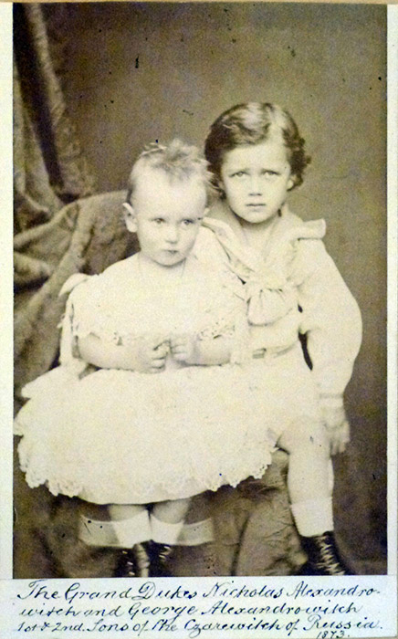 According to historic evidence, the Romanov children were raised in a very strict household. They slept in army beds, woke up at 6 am, and lived and slept in simply-decorated rooms. Only the icon was ornately decorated. / Nikolai and his brother, Grigory (on the left)