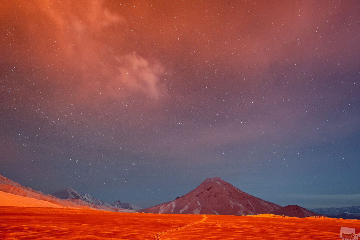 Le magma qui surgit à la surface offre toujours un spectacle de choix, en particulier la nuit. Mais quand le ciel est noir, d&#039;autres images tout aussi intéressantes se dessinent, reflets de la lueur rougeâtre émise par la lave en fusion. Volcan Krasni Tolbatchik, Kamtchatka.