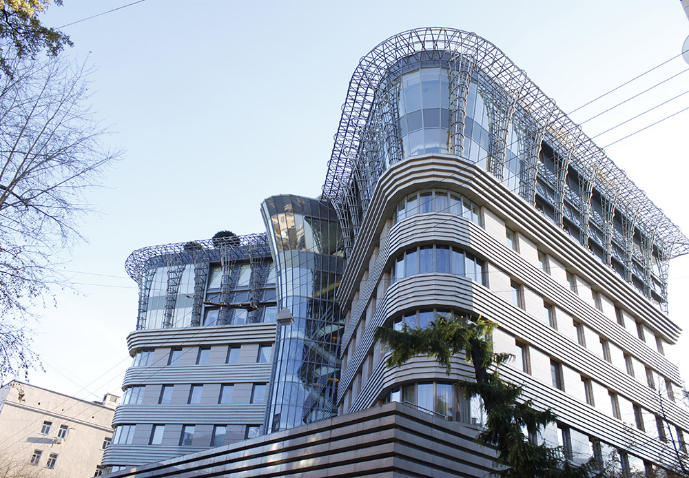 Das „Stolnik-Gebäude“, Malyj-Lewschinski-Gasse 5. Das „Stolnik“ steht in den altehrwürdigen Gassen des Arbat, wo Häuser erhalten sind, die sich noch an Puschkin erinnern. Dieses Wohnhaus aus Glas und Metall sprengt förmlich die architektonische Umgebung. Dennoch hat es irgendetwas undefinierbar Klassisches an sich. Und zwar durch den dreiteiligen symmetrischen Grundriss und das Motiv der „korinthischen Säule“.