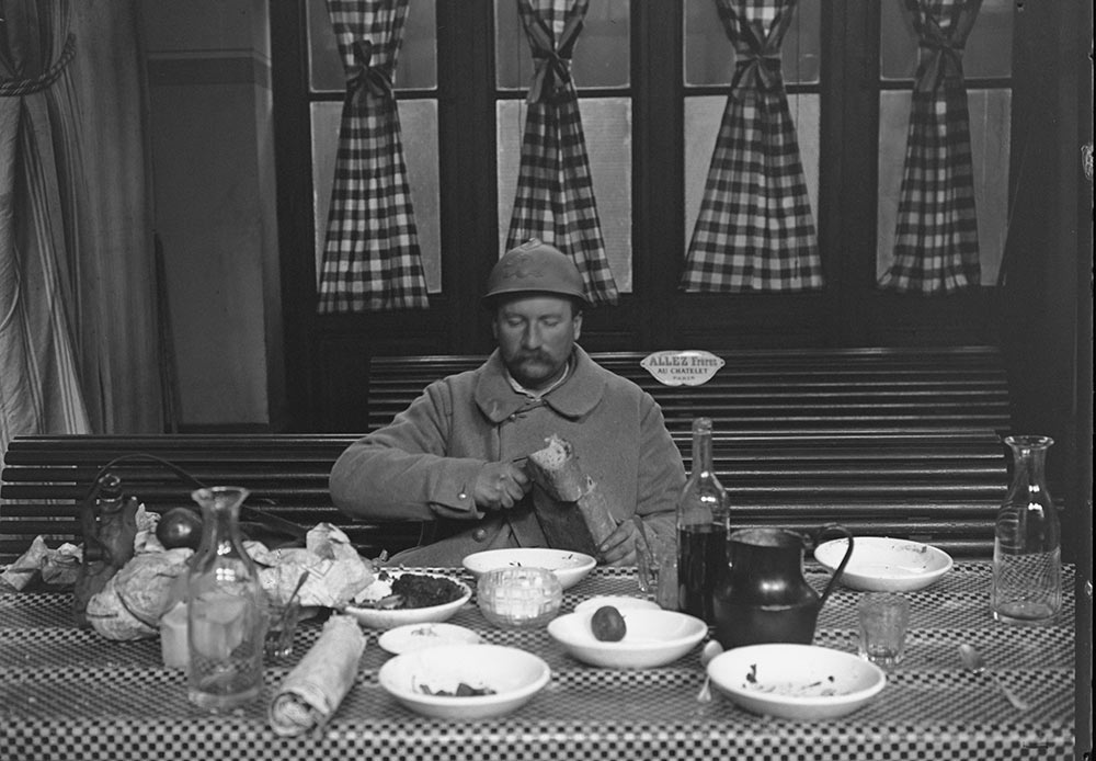 Un militaire en permission dîne dans la cantine militaire de la Gare de l'Est, Jacques Moreau. Paris, janvier 1917.