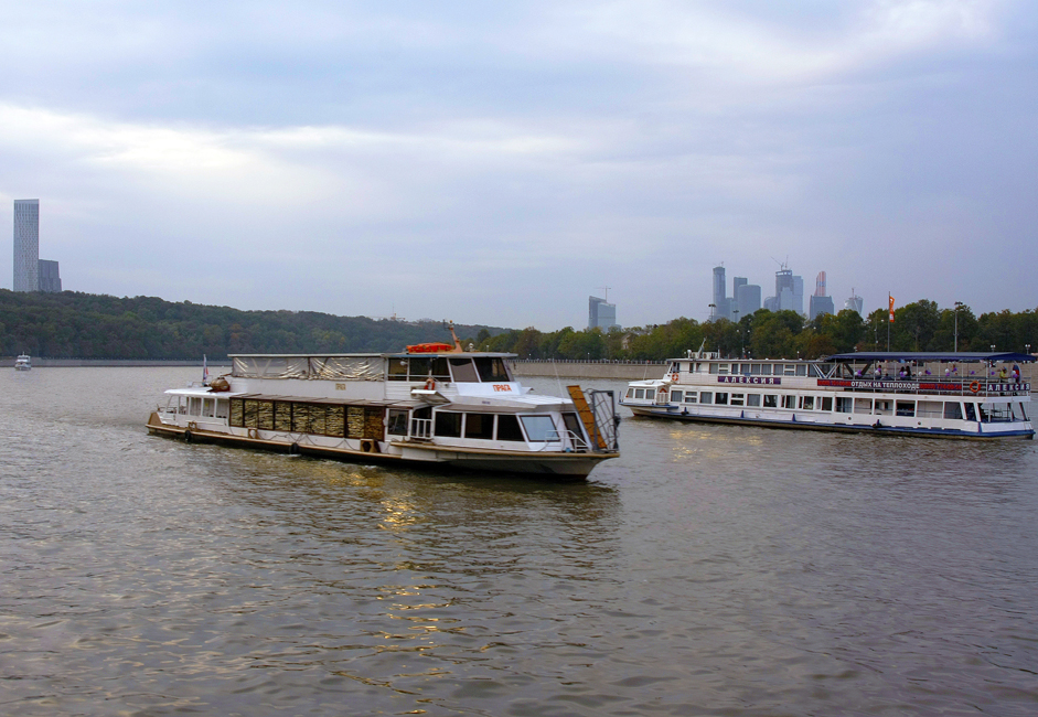 Movement on the Moscow River is really lively. In addition to the Moscow Shipping Company, private boats belonging to small companies also move along the river. Many of them tend to specialize in hosting events (like weddings, birthdays, etc.) // View of Moscow City (right) and a skyscraper on Mosfilmovskaya Street (left).