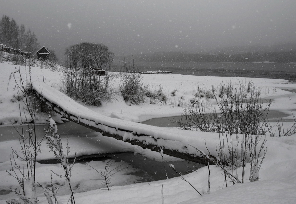 "Pješački most". Sniježi na rijeci Jenisej. Sve je prekriveno bijelim pokrovom i vide se samo rijeka i gusta šuma na obali.