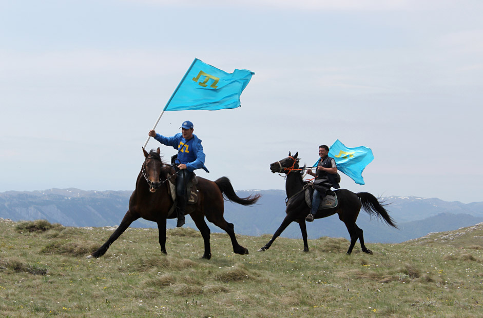 Young Tatars with the Crimean Tatars blue flags make the ascent of the Chatyr-Dag mounts massif to honor the victims of the 1944 deportation of Crimean Tatars, near Alushta, Crimea, on May 16.