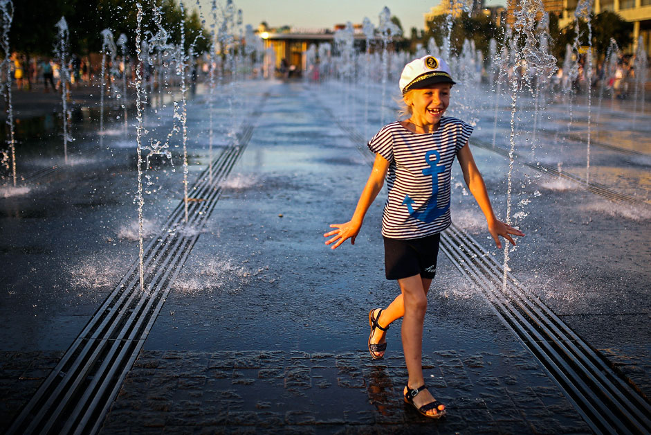 A child cools off in fountains in Muzeon Park in central Moscow in hot weather.