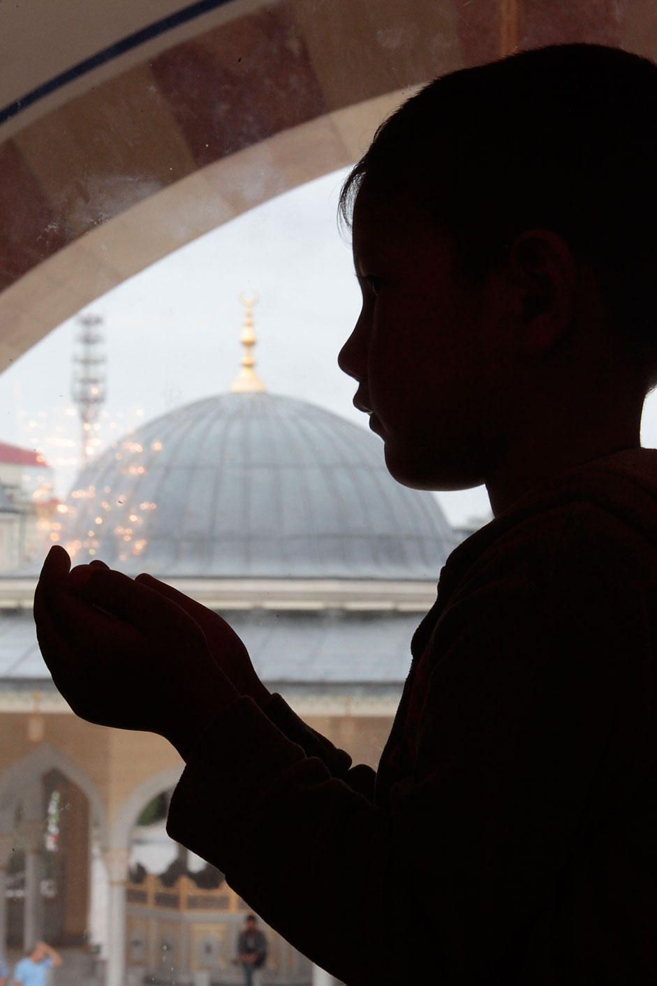 A Chechen boy performs an Eid al-Fitr prayer to mark the end of theholy fasting month of Ramadan in Chechen capital of Grozny, Russia,Friday, July 17, 2015. Eid al-Fitr prayer marks the end of the holyfasting month of Ramadan.