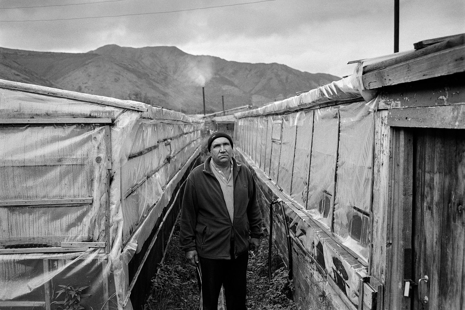 In 1995 the Karamken mining and processing plant was closed down. In 2012 Karamken lost its status of urban-type settlement, and is now in the resettlement list. Valeriy is one of the few remaining residents. He cultivates cucumbers in greenhouses heated with firewood.