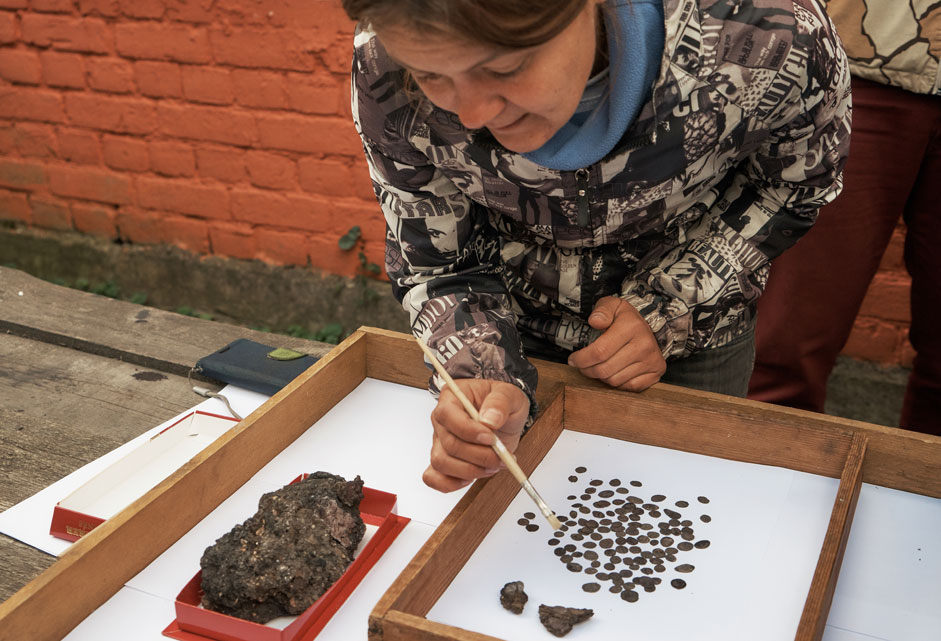 Deputy Head of the archaeological expedition Natalya Grigoryeva demonstrates a hoard of historical artifacts dating back to the times of Ivan the Terrible and Boris Godunov — 116 silver coins, a purse, and fragments of German ceramics. It was discovered during the restoration of the Old Ladoga Fortress in the Leningrad Region on Aug. 18, 2015.