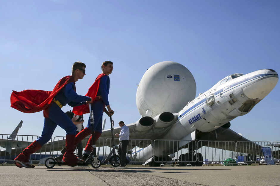 Промотори возат тротинети покрај авионот ВМ-Т Атлант на меѓународната авиокосмичка изложба МАКС во градот Жуковски.