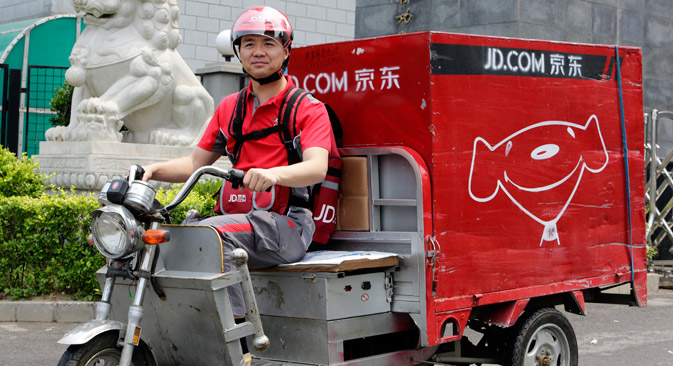 중국 전자 상거래 회사 JD.com의 설립자 리처드 리우가 지난해 6월 16일 회사 창립 기념일 축하의 일환으로 전기 세발 오토바이를 타고 배달에 나섰다.