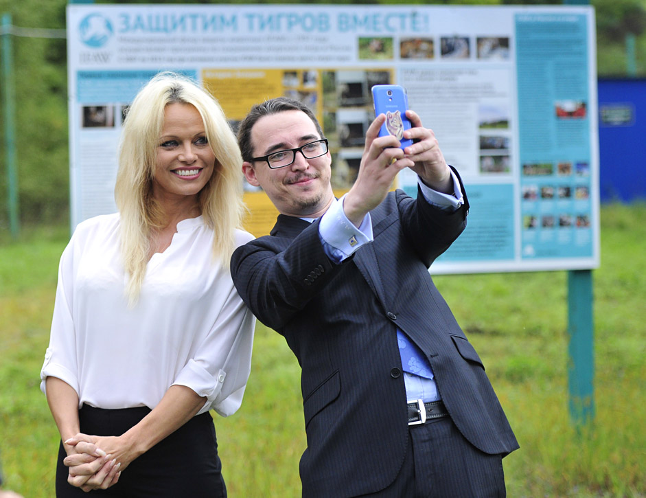 PRIMORYE TERRITORY, RUSSIA. SEPTEMBER 3, 2015. Canadian-American actress and animal rights activist Pamela Anderson (L) poses for a photograph with a man during her visit to a rehabilitation center for the animals affected by flood in Ussuriysk, Primorye Territory.