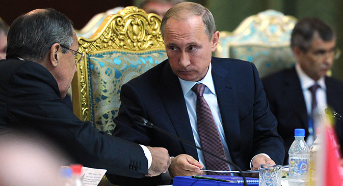 Der russische Präsident Wladimir Putin spricht während des Gipfeltreffens mit dem russischen Außenminister Sergej Lawrow (links) und dem stellvertretenden Sekretär des russischen Sicherheitsrates Raschid Nurgaliew (rechts).  
