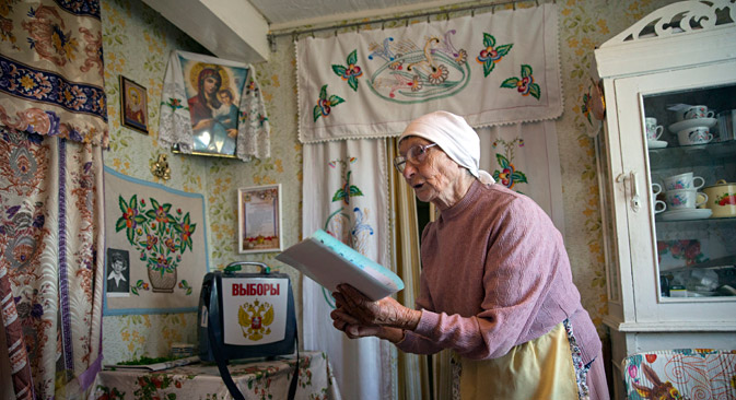 Galina Shalygina, 85, prepares to cast her ballot in a ballot box brought by election officials to villagers unable to travel to the polling station, in the village of Seltso, near Kostroma, 350 km (218 miles) northeast of Moscow, Russia, Sunday, Sept. 13, 2015. Source: AP