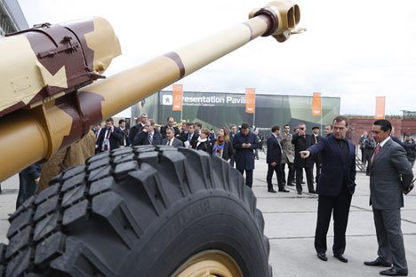 Prime Minister Dmitry Medvedev, center, tours the 2013 Nizhny Tagil display of military equipment (Russia Arms Expo - RAE). Right: Uralvagonzavod general director Oleg Siyenko.