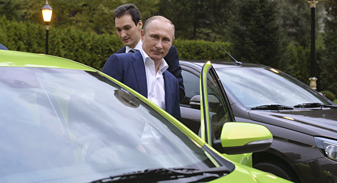 Russian President Vladimir Putin (front) gets into an AvtoVAZ Lada Vesta before driving to attend a session of the Valdai International Discussion Club in Sochi, Russia, October 22, 2015