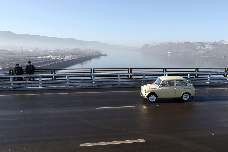 A man drives a Soviet-made Zaporozhets retro car along a new highway bridge during an opening ceremony above the Yenisei River in the Siberian city of Krasnoyarsk, Oct. 29, 2015. 
