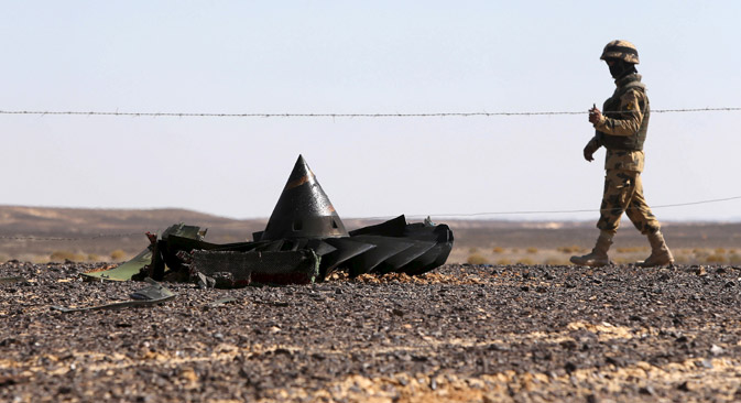 An Egyptian army soldier stands guard near debris from a Russian airliner which crashed at the Hassana area in Arish city, north Egypt, Nov. 1, 2015. 