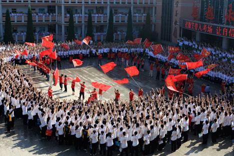 Students cheer as teachers wave flags before the students take their national college entrance exam in Hengshui, Hebei province, June 7, 2014. 