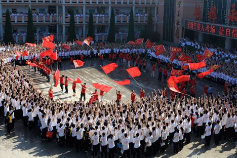 Para siswa bersorak saat guru-guru mereka mengibarkan bendera sebelum pelaksanaan ujian masuk perguruan tinggi nasional di Hengshui, Provinsi Hebei, 7 Juni 2014. Menurut Xinhua News Agency, sekitar 9,39 juta siswa mengikuti ujian masuk perguruan tinggi Tiongkok atau Gaokao tahun itu, yang merupakan ujian dengan persaingan yang sangat ketat dan dipandang sebagai pintu menuju kesuksesan.