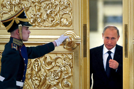 Seorang penjaga kehormatan membukakan pintu saat Presiden Rusia Vladimir Putin (kanan) memasuki aula untuk menghadiri pertemuan dengan anggota Dewan Kepresidenan untuk Masyarakat Sipil dan Hak Asasi Manusia di Kremlin, Moskow, Rusia, 1 Oktober 2015.