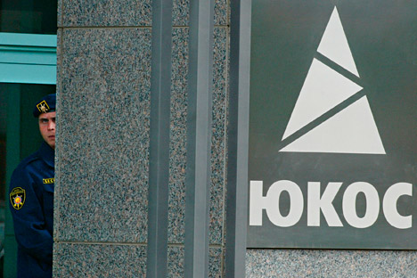 A guard looks from an entrance of Yukos oil company headquarters in Moscow, Thursday, July 22, 2004.