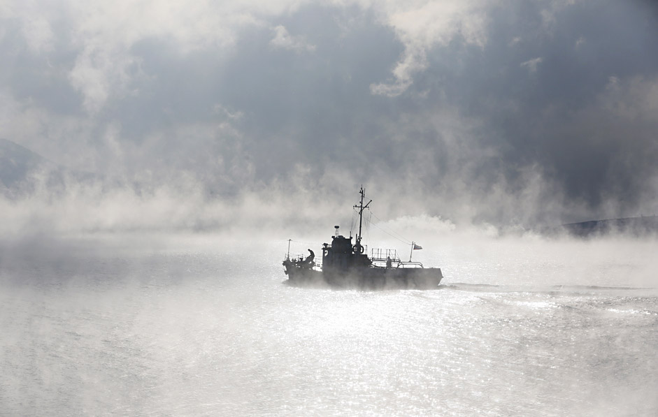 A motor boat travels through the frosty fog along the Yenisei River at air temperature some minus 21 degrees Celsius in the Taiga district outside the Siberian city of Krasnoyarsk, Russia