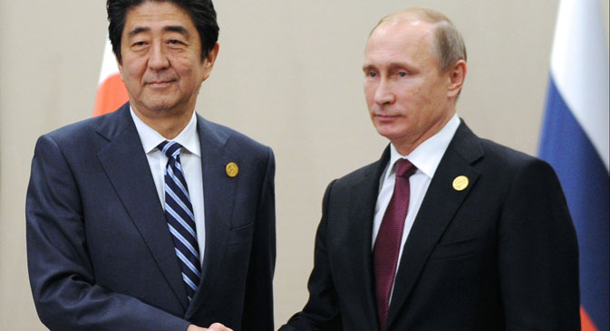 Japanese Prime Minister Shinzo Abe (L) shakes hands with Russian President Vladimir Putin (R) during the G-20 Summit in Antalya, Turkey, Nov. 16, 2015.