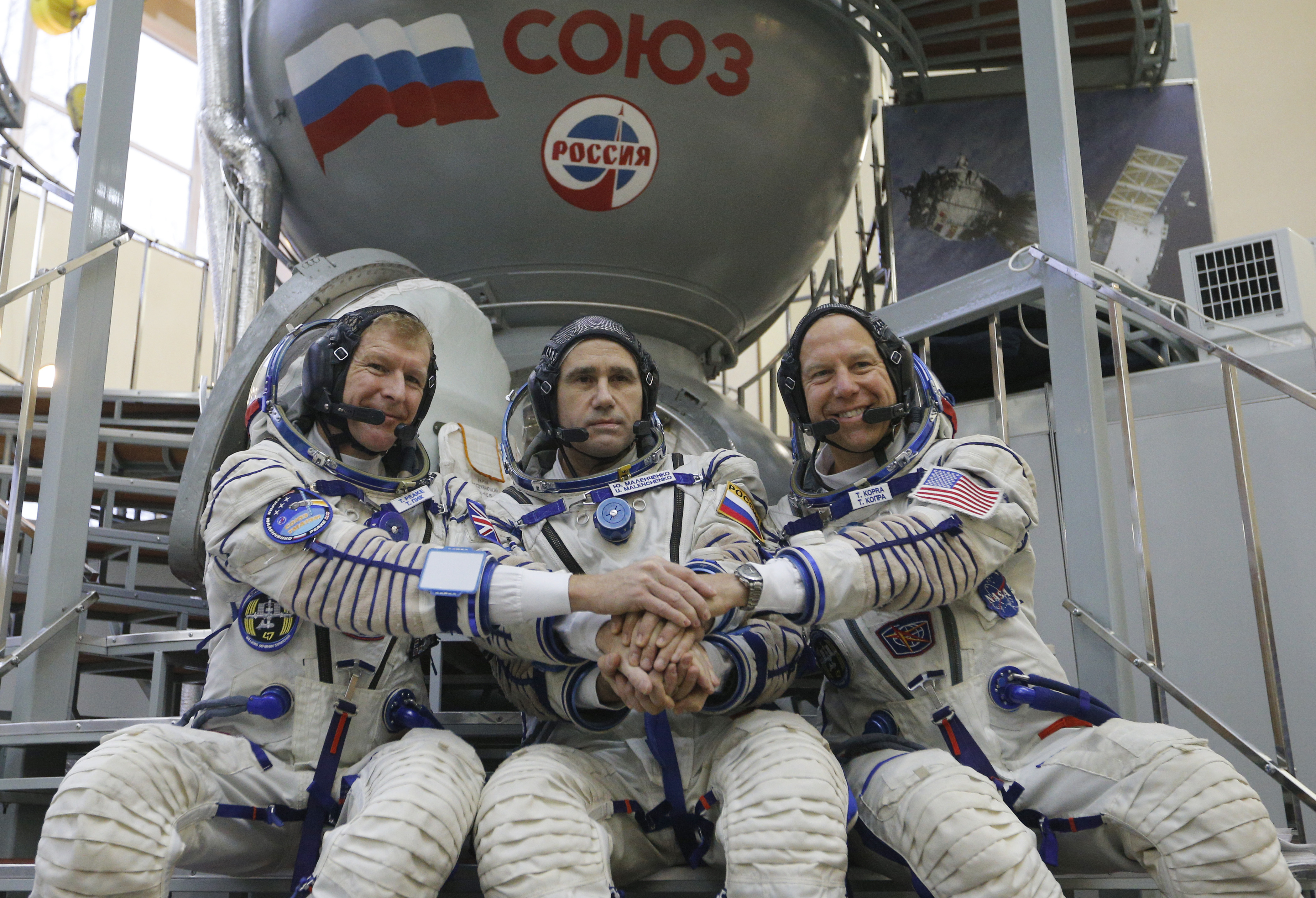 British ESA astronaut Timothy Peake, Russian cosmonaut Yuri Malenchenko and US NASA astronaut Timothy Kopra pose for the media in front of Soyuz space craft simulator prior to pass final exams in the Russian cosmonaut training center in Star City outside Moscow, Russia. Launch of the mission is scheduled on 15 December from cosmodrome Baikonur (Kazakhstan). 