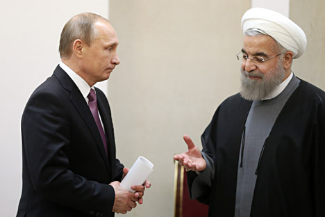 Iran's President Hassan Rouhani, right, makes his way to shake hands with Russian President Vladimir Putin after signing documents during the Gas Exporting Countries Forum (GECF) in Tehran.