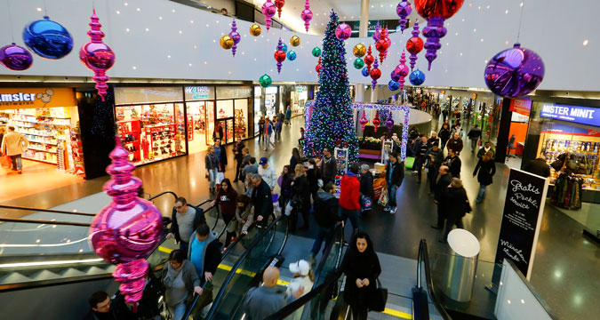 Shoppers walk under Christmas decorations at the Sihlcity shopping mall during a special Sunday sale in Zurich December 22, 2013