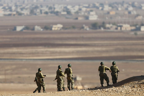 Turkish soldiers watch fighting between Kurdish fighters and Islamic State militants from atop a hill overlooking the Syrian town of Kobani, near the Mursitpinar border crossing on the Turkish-Syrian border in Sanliurfa province November 10, 2014.