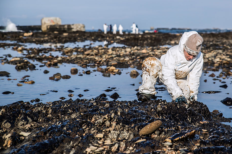 Eine Freiwillige hilft, die mit Öl verschmutzte Küste von Newelsk in der Oblast Sachalin zu reinigen.