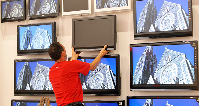  A worker installs a flat screen LCD TV set of Toshiba