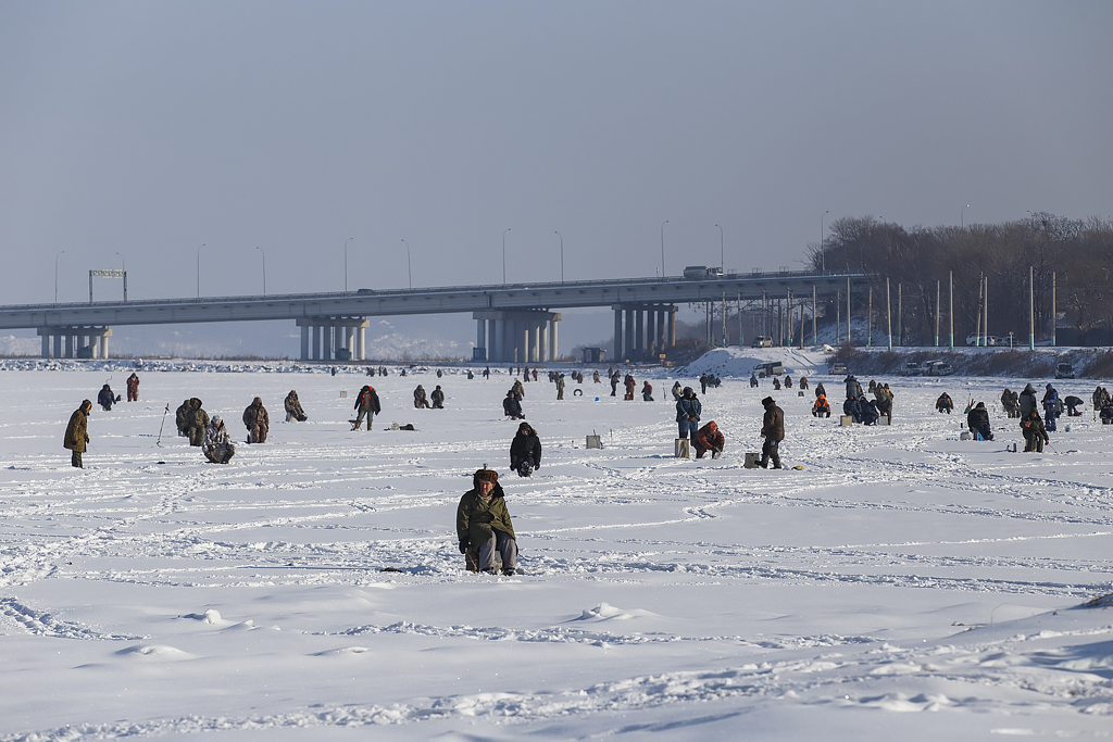 凍った海面上の釣り人