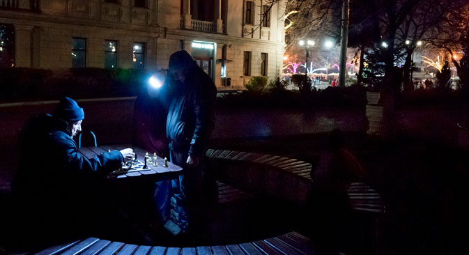 People play chess holding a flashlight near Nakhimov's Square in Sevastopol, Crimea, Dec. 27.